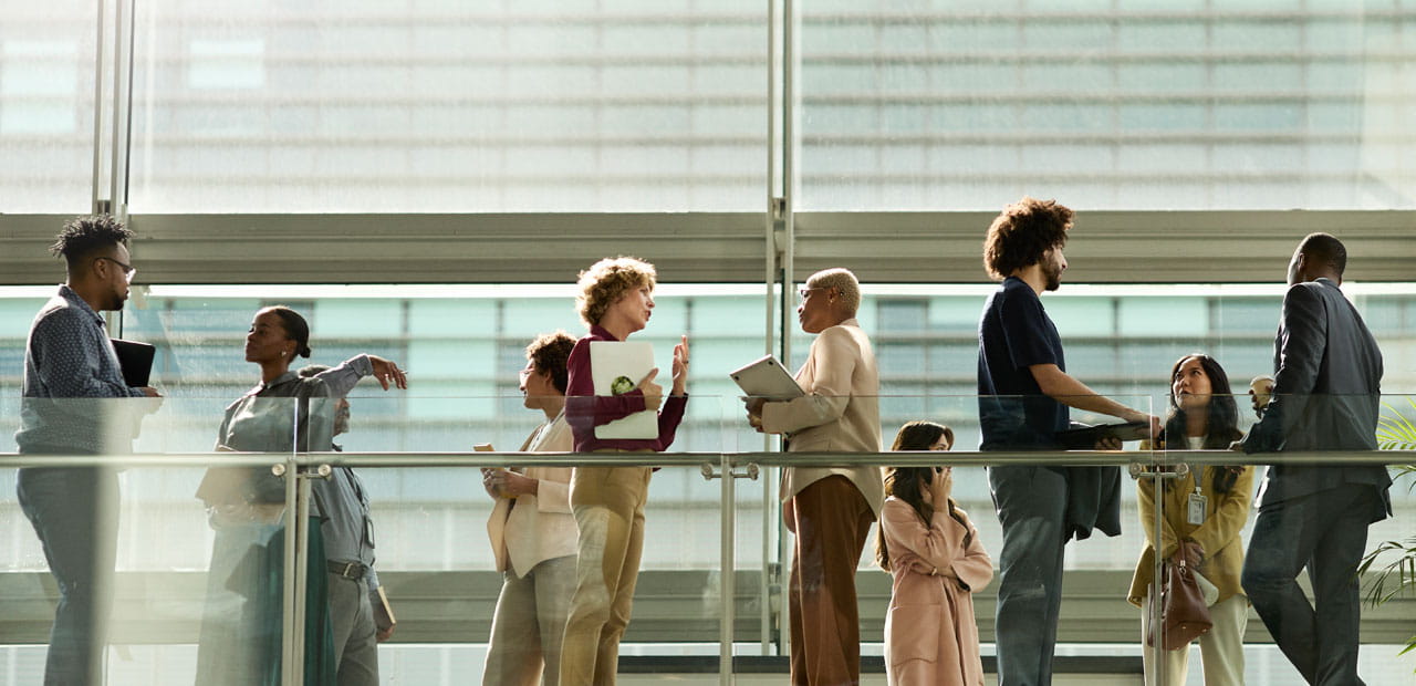Business colleagues standing and talking in a bright, modern building corridor