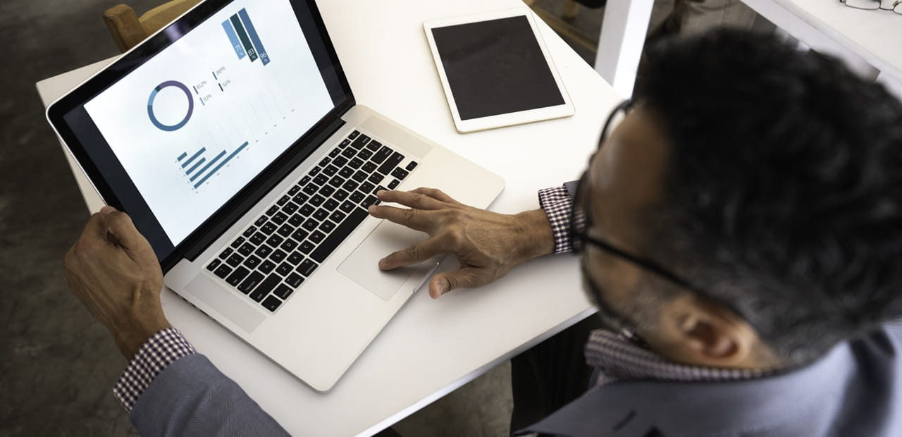 Business owner reviewing financial dashboards on a laptop, illustrating smart cash management to power business growth.